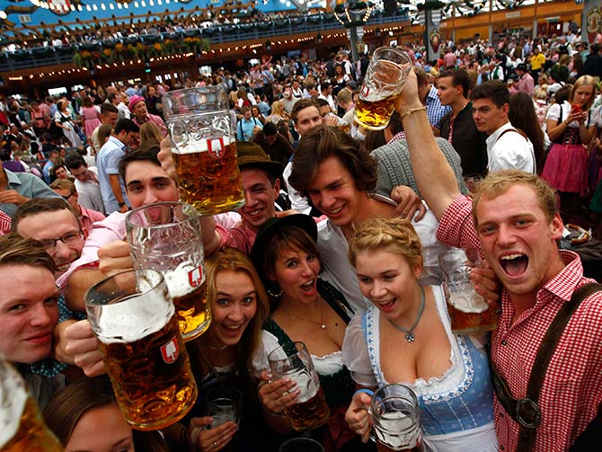 Visitors cheer with mugs of beer during the opening day the 180th Oktoberfest in Munich.