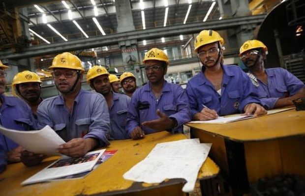 Employees check papers during their meeting after their lunch break inside the heavy electrical manufacturing unit of Larsen & Turbo in Mumbai.