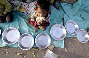 Image: A homeless boy eats as he begs for money in Kolkata. Photograph: Parth Sanyal/Reuters