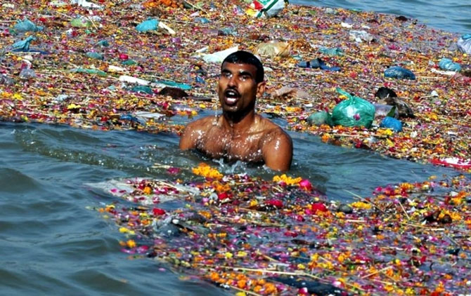 A man takes a dip in the polluted waters of river Ganga in Allahabad. Photograph: Jitendra Prakash