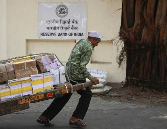 A man pulls a hand-drawn cart in front of the Reserve Bank of India building in Mumbai.