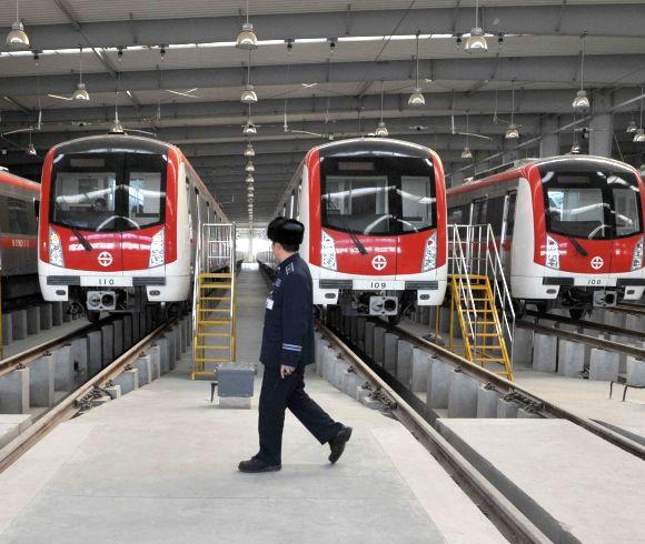 Technicians service a train in a station during a media visit to the new Shanghai Metro Line.