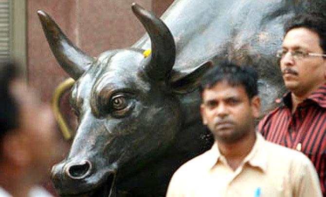 A man walks past the Bull at the Bombay Stock Exchange.