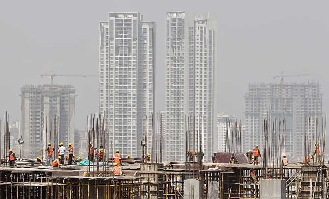 Labourers work at a construction site of a commercial complex