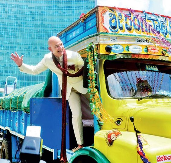 Amazon founder and CEO Jeff Bezos poses as he stands on a supply truck during a photo opportunity at the premises of a shopping mall in Bengaluru
