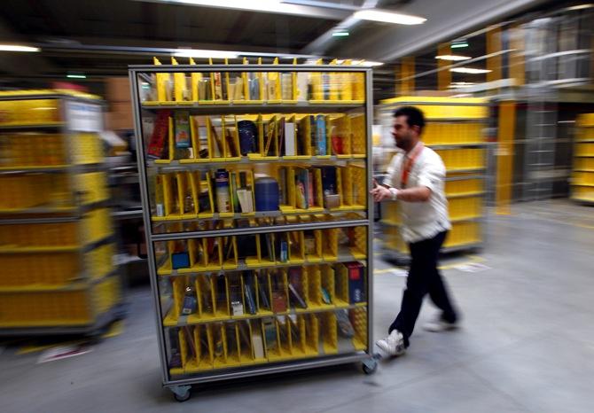 A worker collects items to pack into boxes at Amazon's logistics centre in Graben near Augsburg.