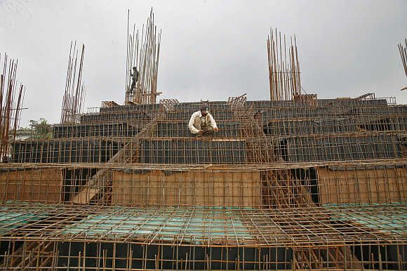 Labourers work at a construction site of a stadium in Agartala, Tripura.