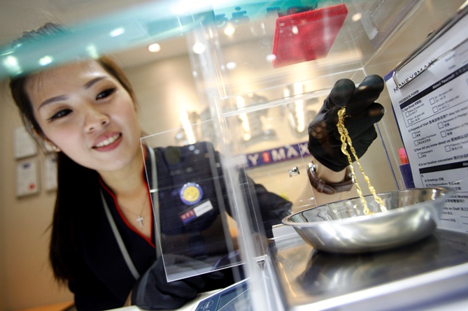 Valuer Eve Chong, demonstrates the valuation process for jewellery at a MoneyMax pawn shop outlet.