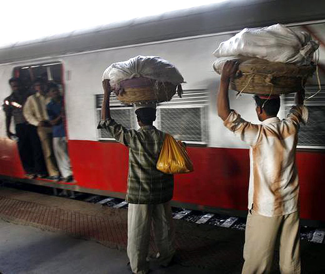 Hawkers carrying baskets of bananas prepare to board a train at a railway station in Mumbai.