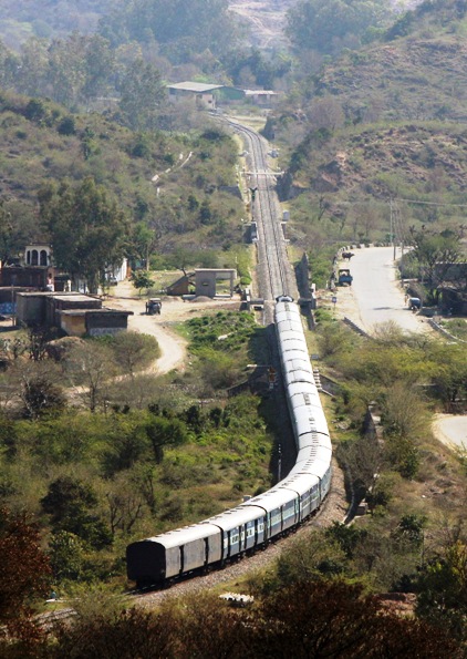 A passenger train moves along the Jammu-Udhampur rail line on the outskirts of Jammu.