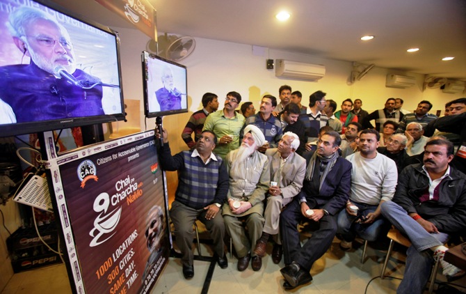 Supporters of Bharatiya Janata Party listen to Gujarat's chief minister Narendra Modi, the prime ministerial candidate for BJP, during a live video broadcast campaign on 'Talk over tea with Modi', in Chandigarh.