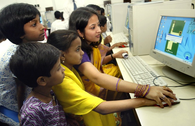 A trainer teaches Indian children how to use the computer in Kolkata.