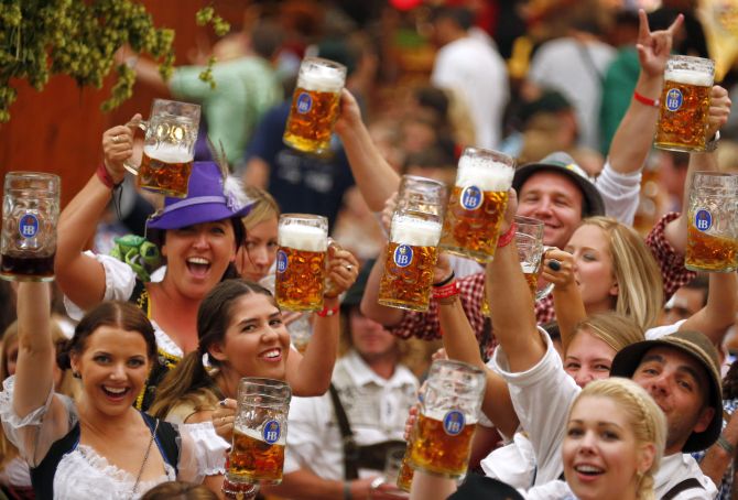 Revellers toast after getting the first beer in the traditional one-litre Masskrug beer mugs at the opening day of the Munich Oktoberfest at the Theresienwiese in Munich.
