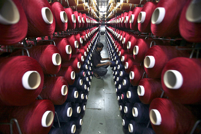 An employee works at the production line of a carpet manufacturing factory in Jammu