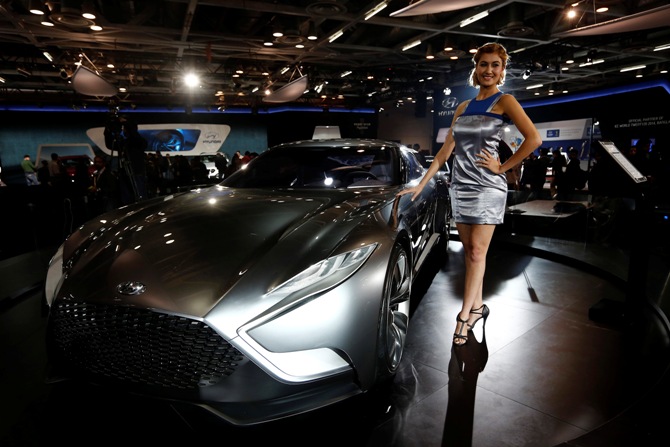 A model stands next to a Hyundai HND-9 Venace concept car during the Indian Auto Expo in Greater Noida on the outskirts of New Delhi, February 5, 2014.
