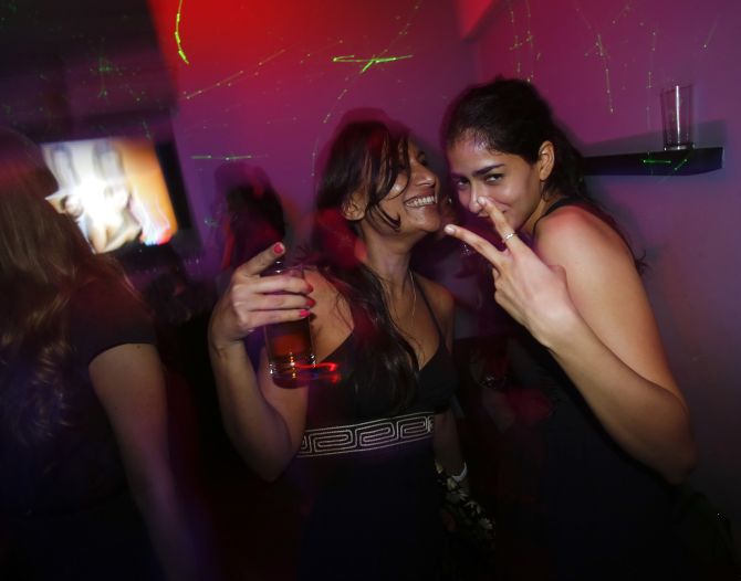 Malini Agarwal (L), blogger-in-chief of missmalini.com, smiles as she dances with a friend at a newly-opened nightclub in Mumbai.