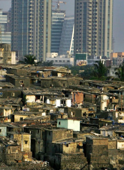 High rise buildings are seen behind a slum in Mumbai.