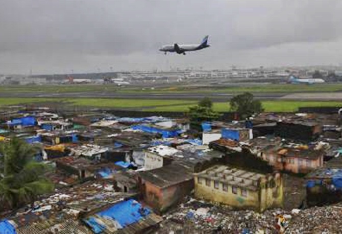 An aircraft prepares to land at the airport surrounded by slums in Mumbai.