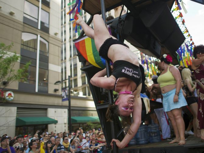 A woman dances on a pole on the back of a truck as she takes part in a parade in Toronto.