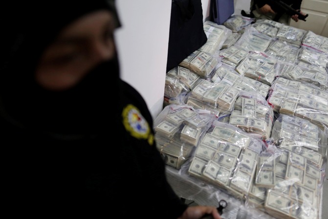Panama police stand guard over $7 million confiscated by the police during a news conference in Panama City January 13, 2014.