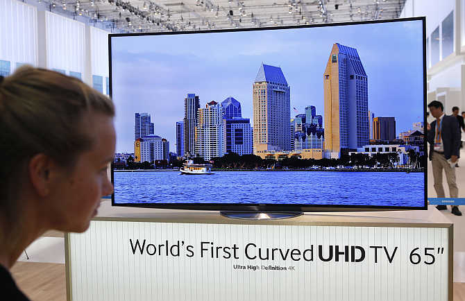 A women looks at the world's first curved UHD TV 55 4K screen at the booth of Samsung at the IFA consumer electronics fair in Berlin, Germany.
