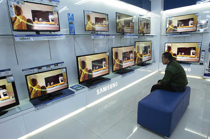 A visitor looks at television screens in a shopping centre in Makassar in South Sulawesi province, Indonesia.
