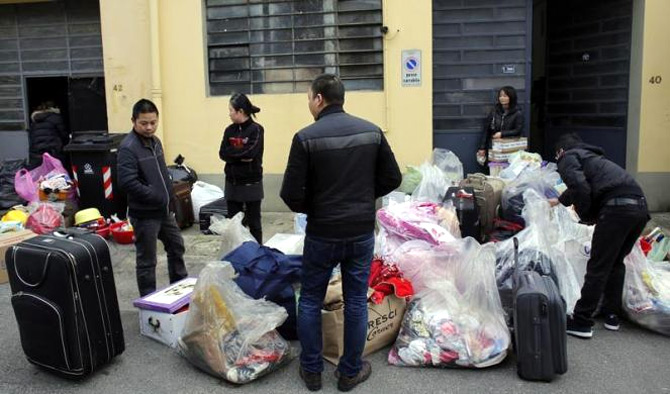 Chinese immigrants pack their belongings after police officers finished checking the Shen Wu textile factory in Prato.