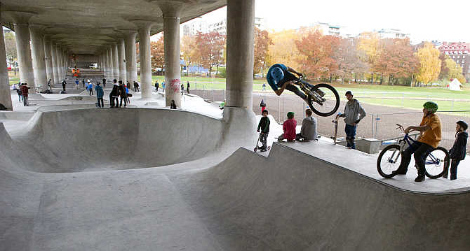 Children try out a skateboard park built under a concrete viaduct in Ralambshov Park in central Stockholm, Sweden.