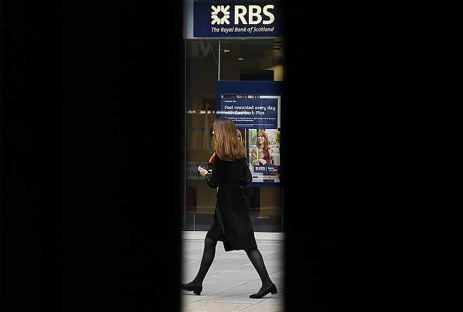 A woman is seen through scaffolding as she walks past a branch of the Royal Bank of Scotland in London. Drummonds Bank is part of RBS's portfolio.