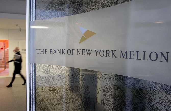 A woman walks past a logo at the office of the Bank of New York Mellon in Brussels, Belgium.