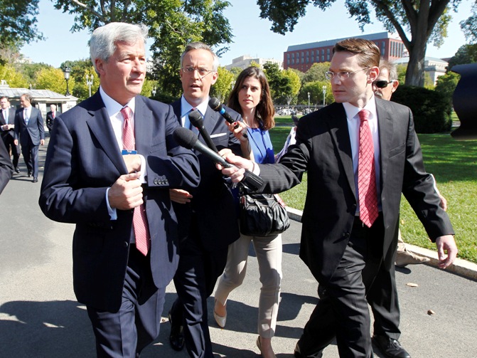 Jamie Dimon (L), chairman and CEO of JP Morgan Chase, is questioned by journalists as he and other CEOs arrive at the White House in Washington, October 2, 2013, for a meeting of the Financial Services Forum with US President Barack Obama. 