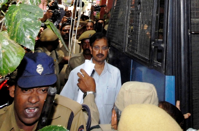 Ramalinga Raju (C), founder and former chairman of fraud-hit Satyam Computer Services, is escorted from a court in Hyderabad, April 9, 2009.