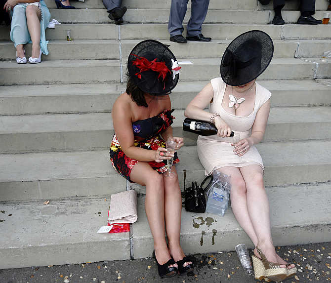 Racegoers drink champagne during the racing on Ladies Day during the Epsom Derby festival in Epsom, southern England.
