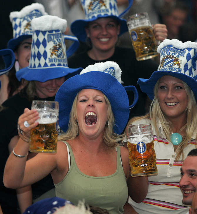 A woman shouts out as she drinks beer during the Munich's Oktoberfest, Germany.