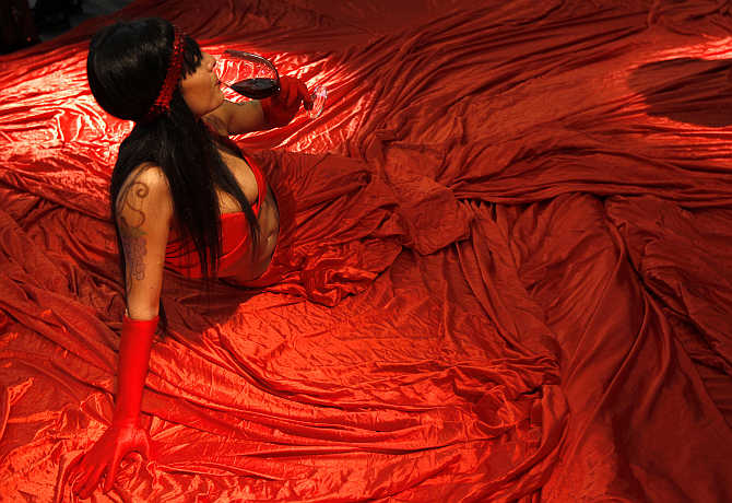 A model holds a glass of red wine during the Vinitaly wine expo in Verona, Italy.