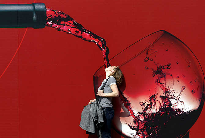 A woman poses for a friend's picture at the Vinitaly wine expo in Verona, Italy.