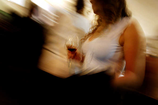 A woman holds a glass of red wine during a wine testing event in Santiago, Chile.