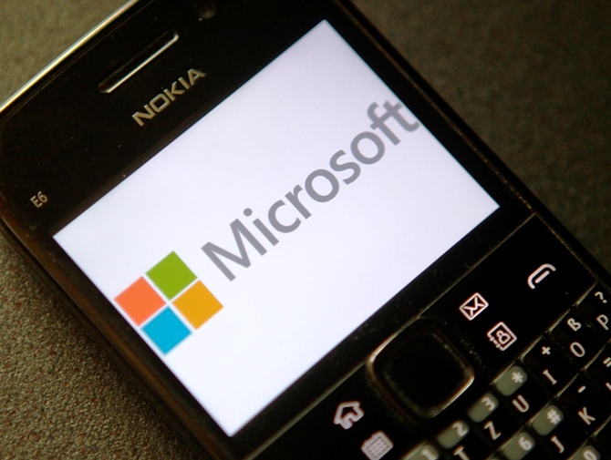 A photo illustration shows the Microsoft logo displayed on a Nokia phone.