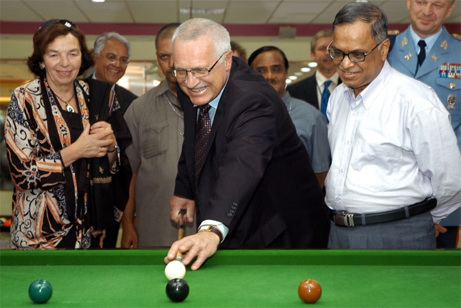 File photo of Vaclav Klaus (C), President of the Czech Republic, plays billiards as his wife Livia Klausova (L) and Narayana Murthy (R, white shirt), look on.