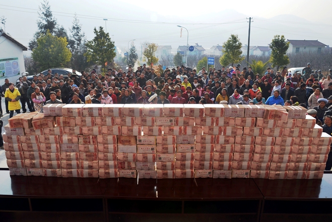 Villagers wait to collect their year-end bonus at Jianshe village, Liangshan, Sichuan province, January 14, 2014.