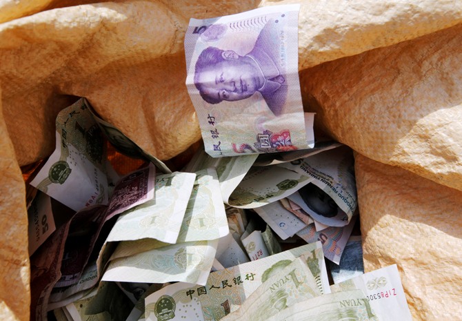 Chinese Yuan bank notes are seen in a vendor's cash sack at a market in Beijing.