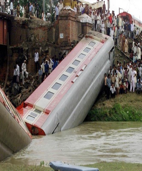 People crowd near the submerged coach of a luxury train destroyed in an accident in Rafiganj, near Patna.