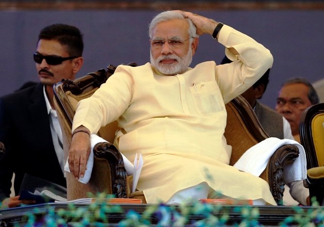 Gujarat's chief minister Narendra Modi sits before addressing his party's supporters during a rally ahead of the 2014 general elections, in Mumbai December 22, 2013.