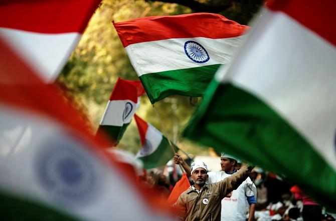 Supporters of Arvind Kejriwal, leader of the newly formed Aam Aadmi Party, wave India's national flag during the first party workers' meeting after their party won 28 constituencies in the state assembly elections, in New Delhi December 11, 2013.