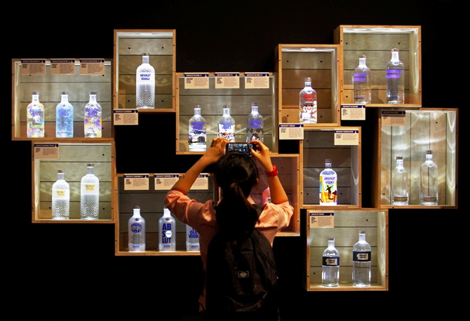 A visitor takes photos of limited edition Absolut Vodka bottles at the Absolut Canvas vodka exhibition at the Singapore National Museum.