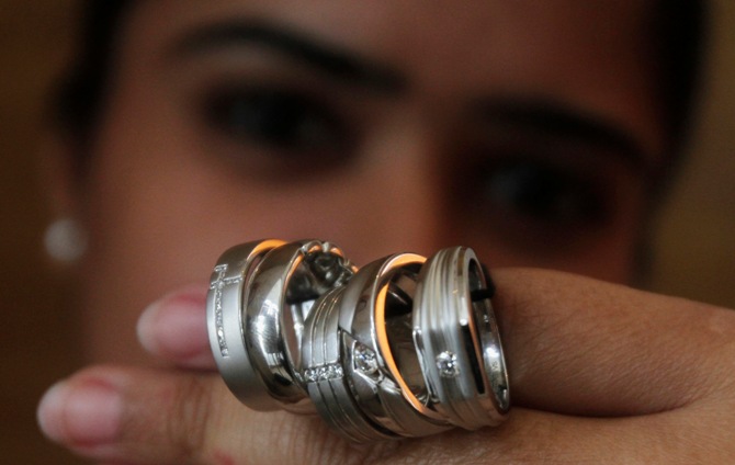 A saleswoman displays platinum rings for the camera at a jewellery showroom in New Delhi.