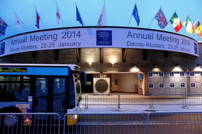A bus drives past the entrance of the congress centre for the annual meeting of the World Economic Forum (WEF) 2014 in the early morning in Davos January 21, 2014. 