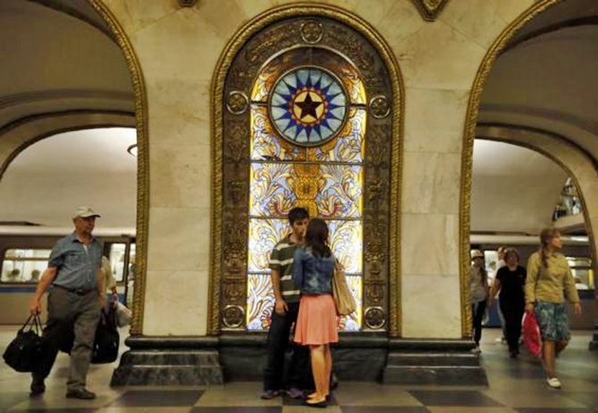 A couple in front of a stained glass panel in Novoslobodskaya metro station, which was built in 1952, in Moscow.