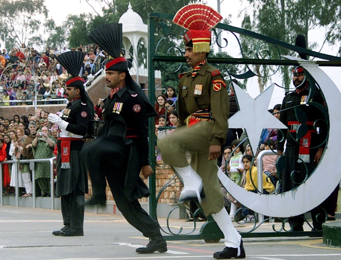 An Indian border security soldier (R) and Pakistani rangers (L) perform during a parade during a retreat ceremony at the Indo-Pak Joint check post in Wagha.