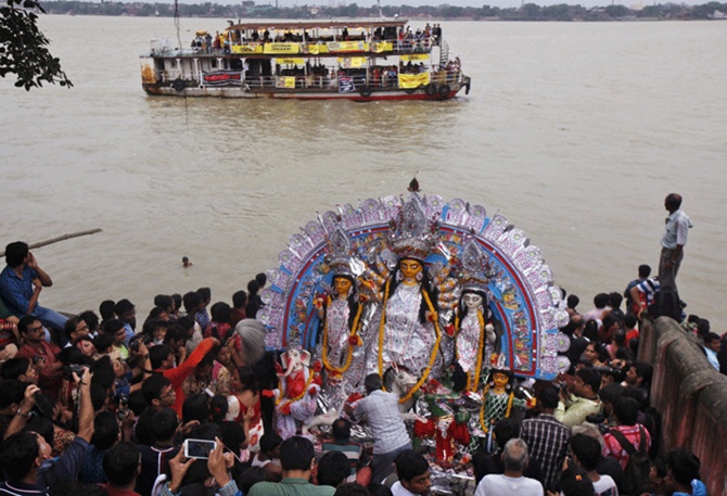 Devotees prepare to immerse an idol of goddess Durga in the waters of river Ganges on the last day of the Durga Puja festival in Kolkata. 